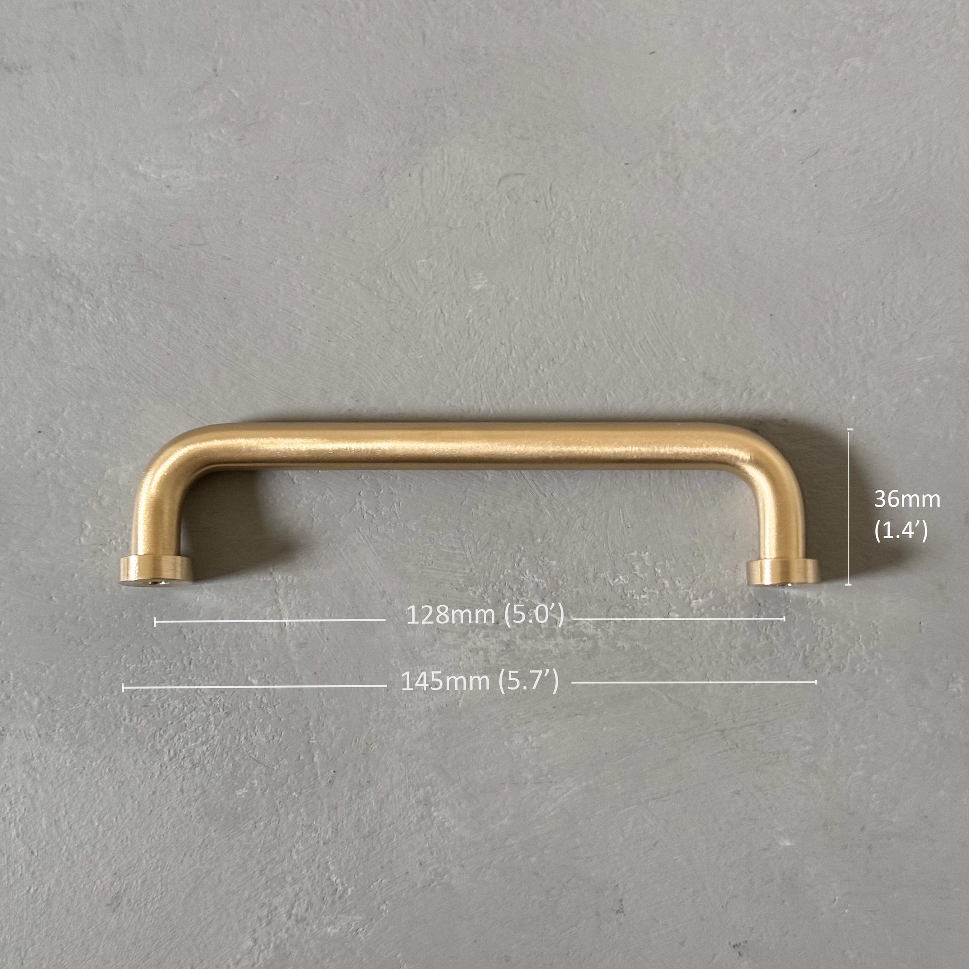 one rounded brass bar handle medium size on grey background