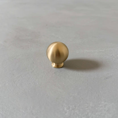 one small brass knob on grey background