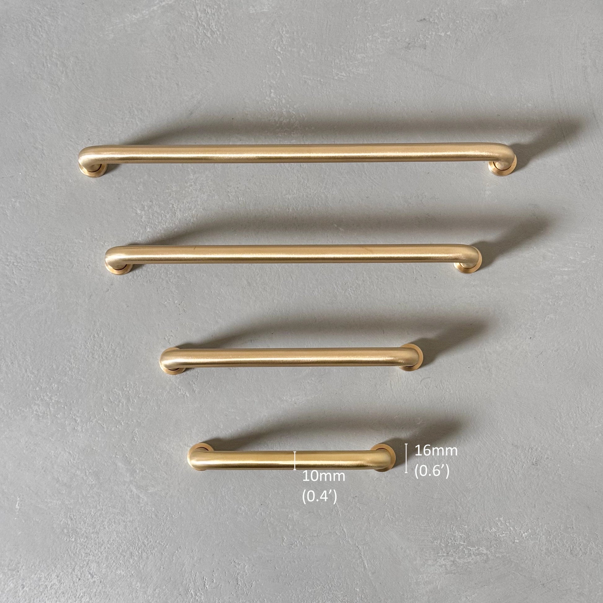 four rounded brass bar handles taken from top down