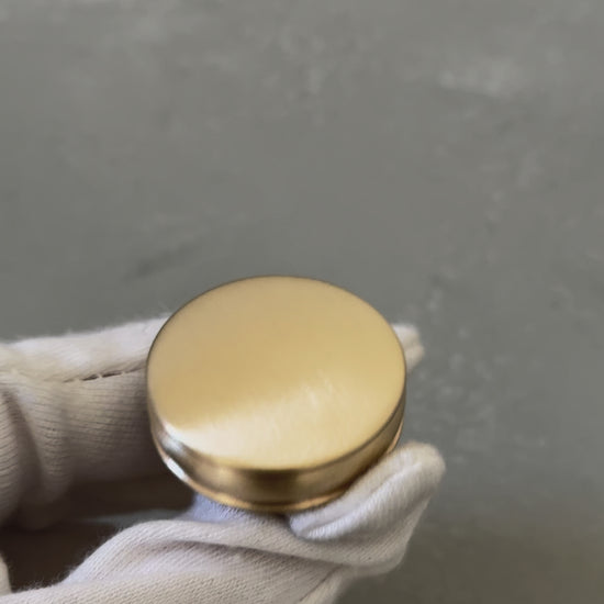 video of one bevel round knob with grooves on a white glove palm