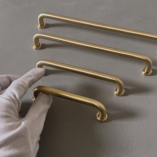 video of four rounded brass bar handles