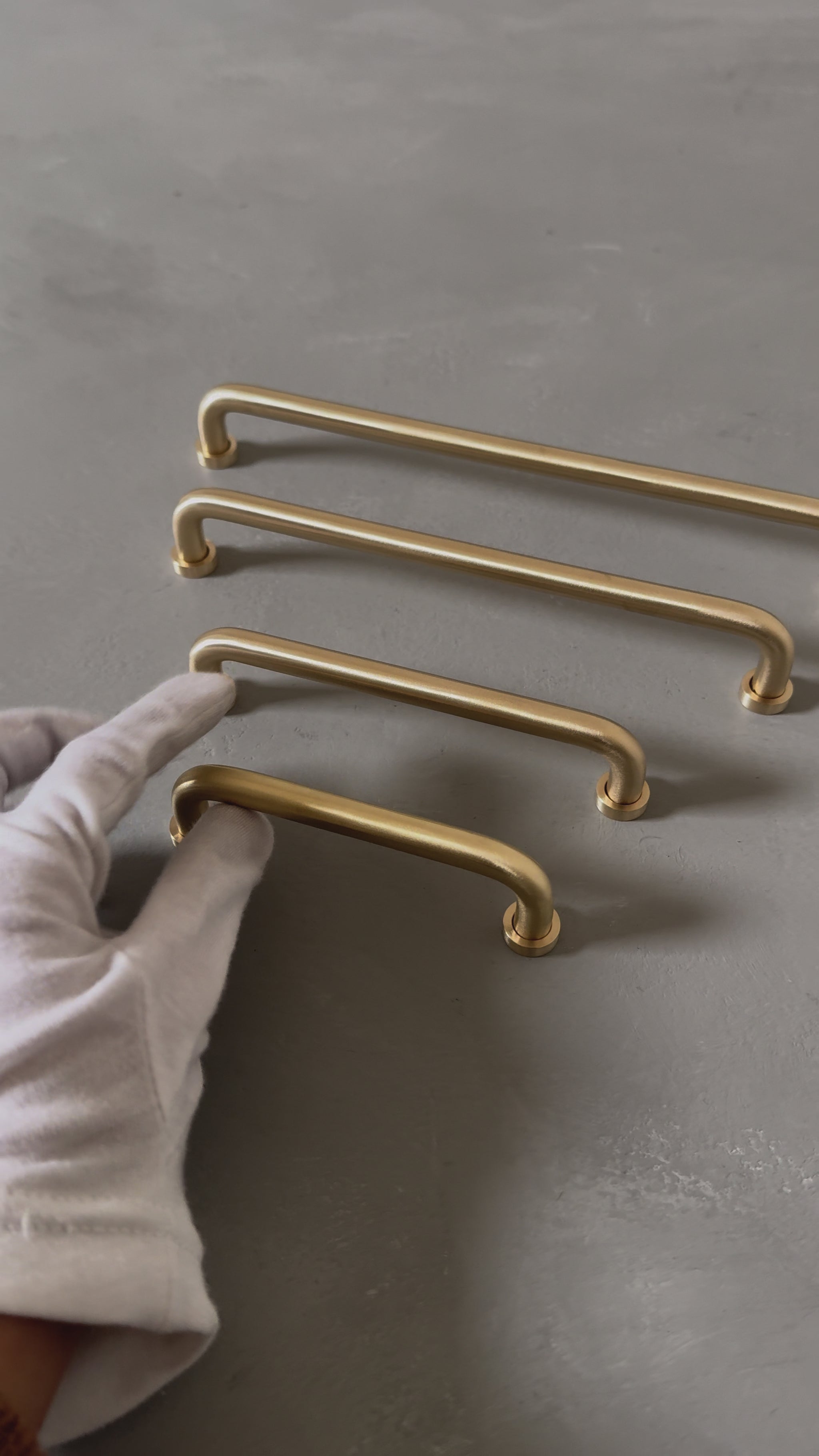 video of four rounded brass bar handles